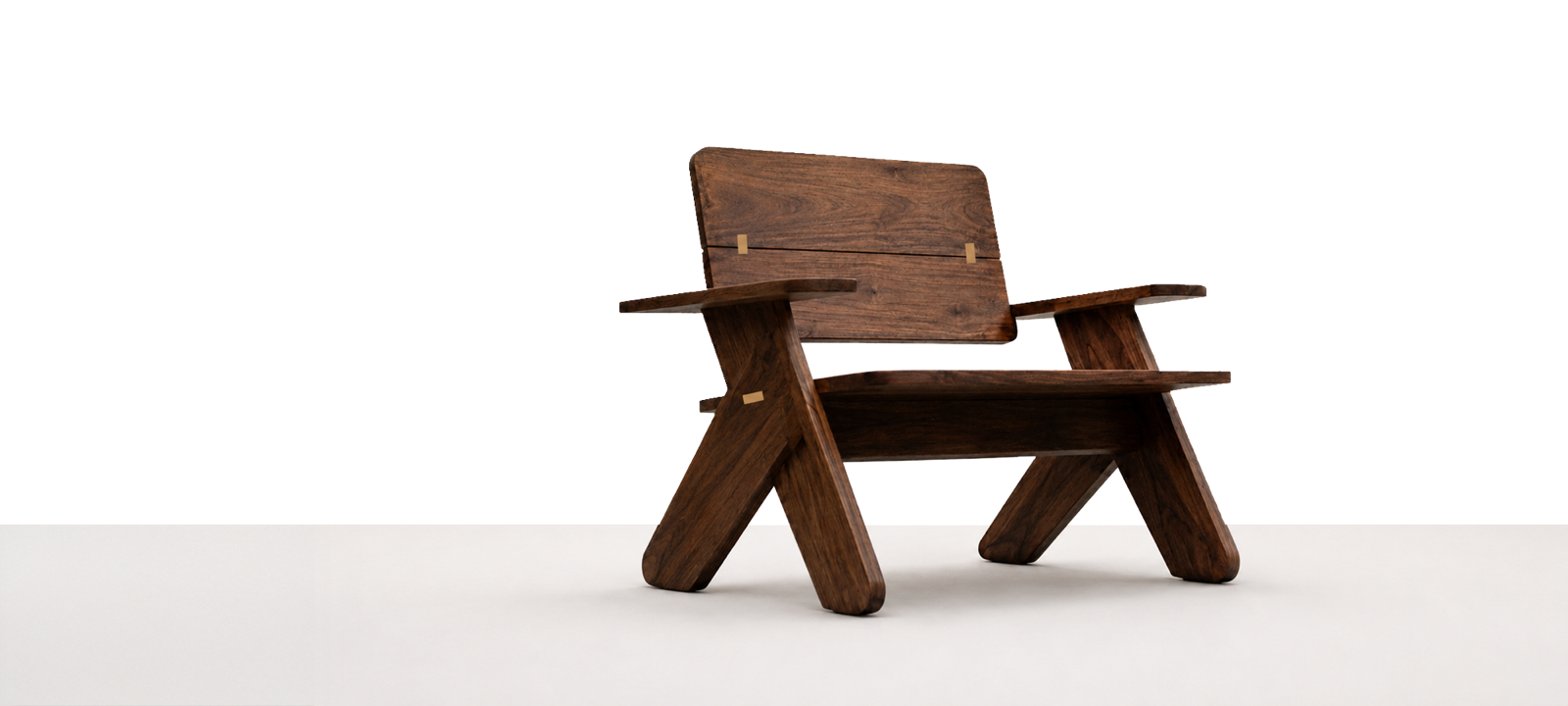 The Portland Chair — a sculptural solid-walnut lounge chair with brass inserts